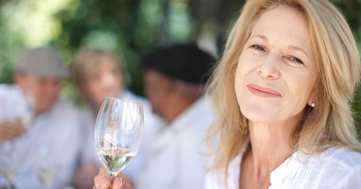 Older woman enjoying a glass of wine outside