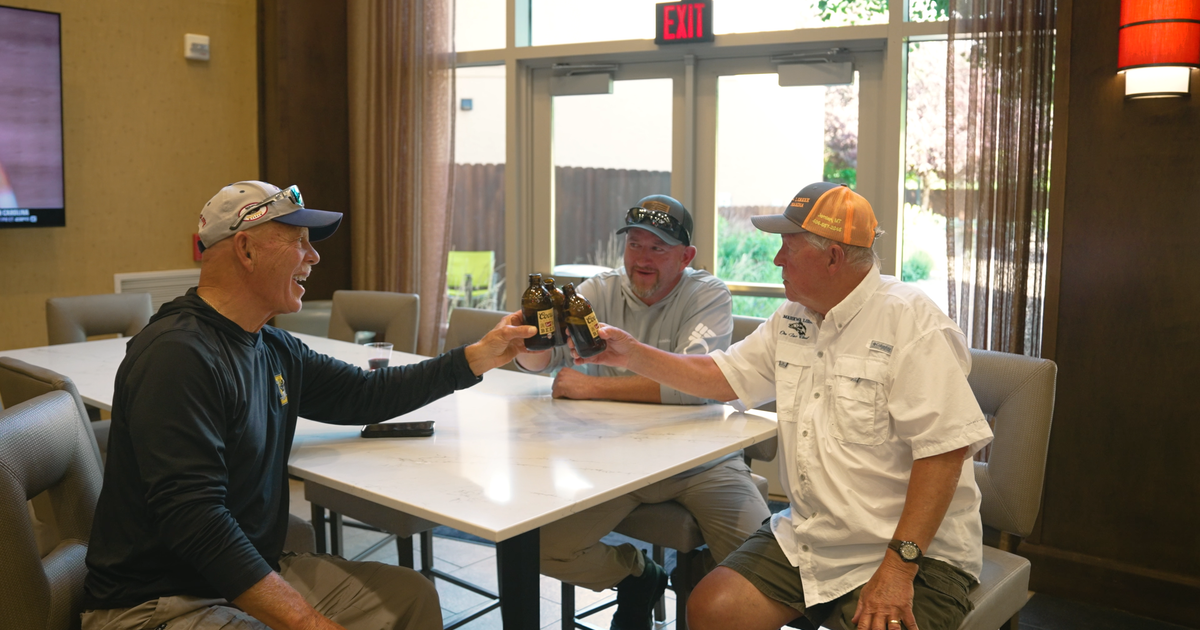 A group of three men enjoying beers in the hotel great room
